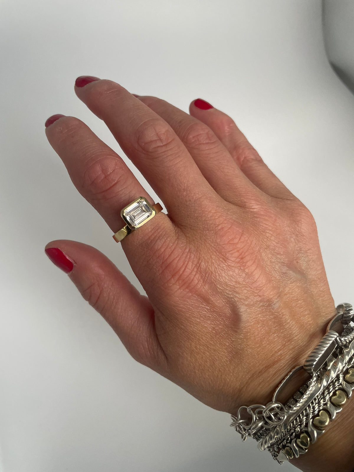 Emerald-cut cubic zirconia bezel ring worn on the hand