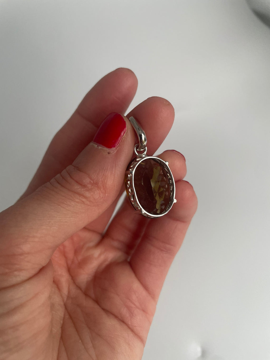 Sterling silver pendant with a large faceted oval smoky quartz, front view