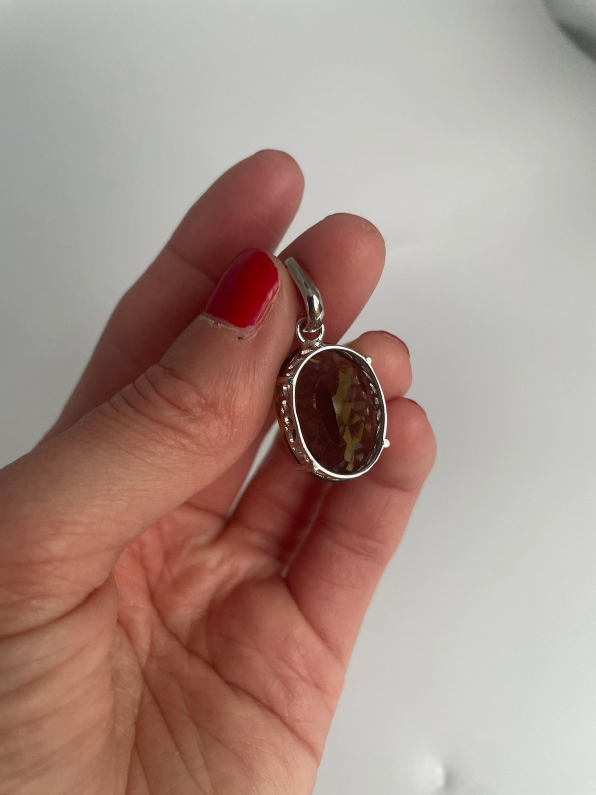 Sterling silver pendant with a large faceted oval smoky quartz, front view