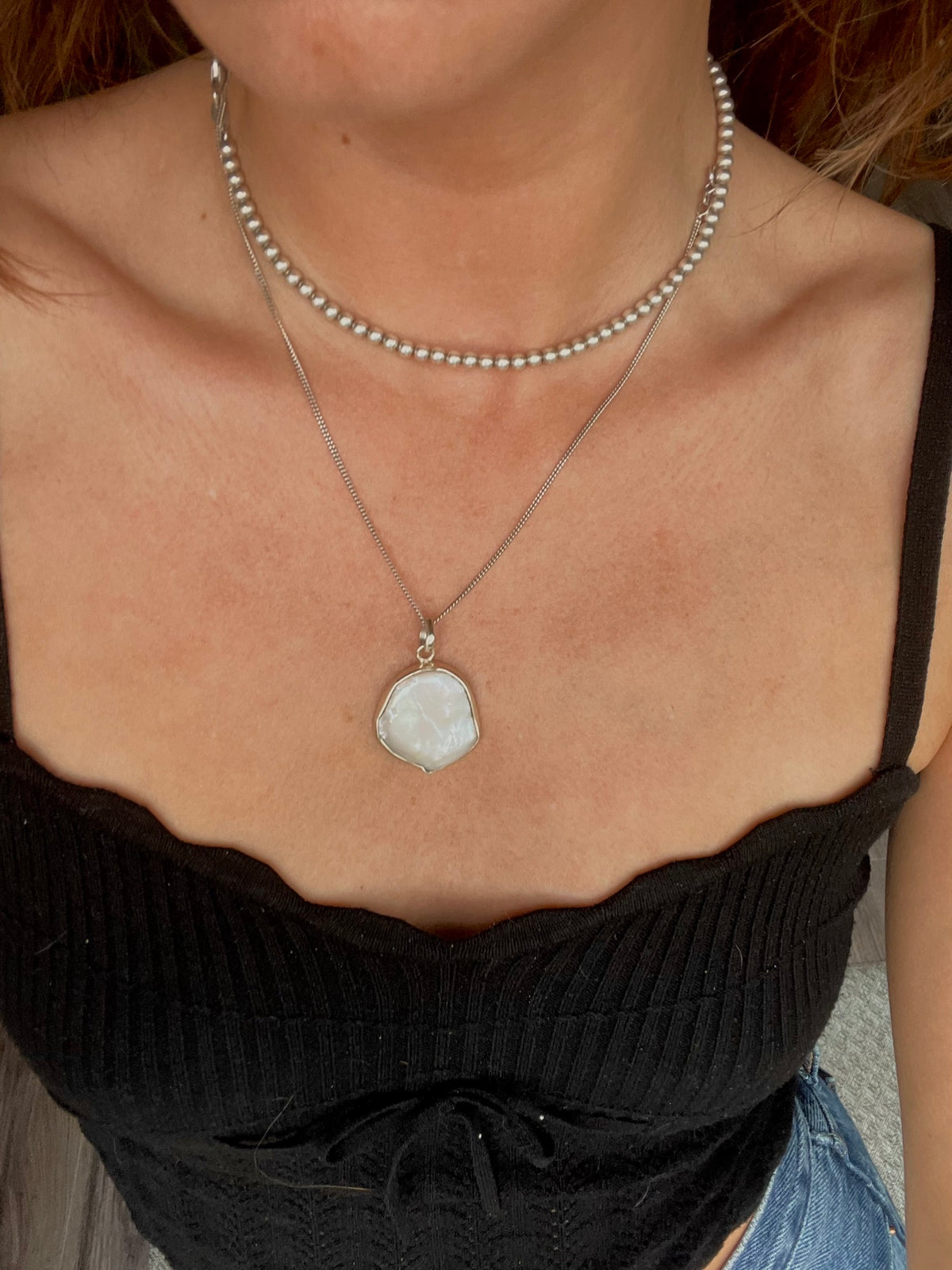 Baroque pearl pendant worn at the neckline with a beaded choker for styling