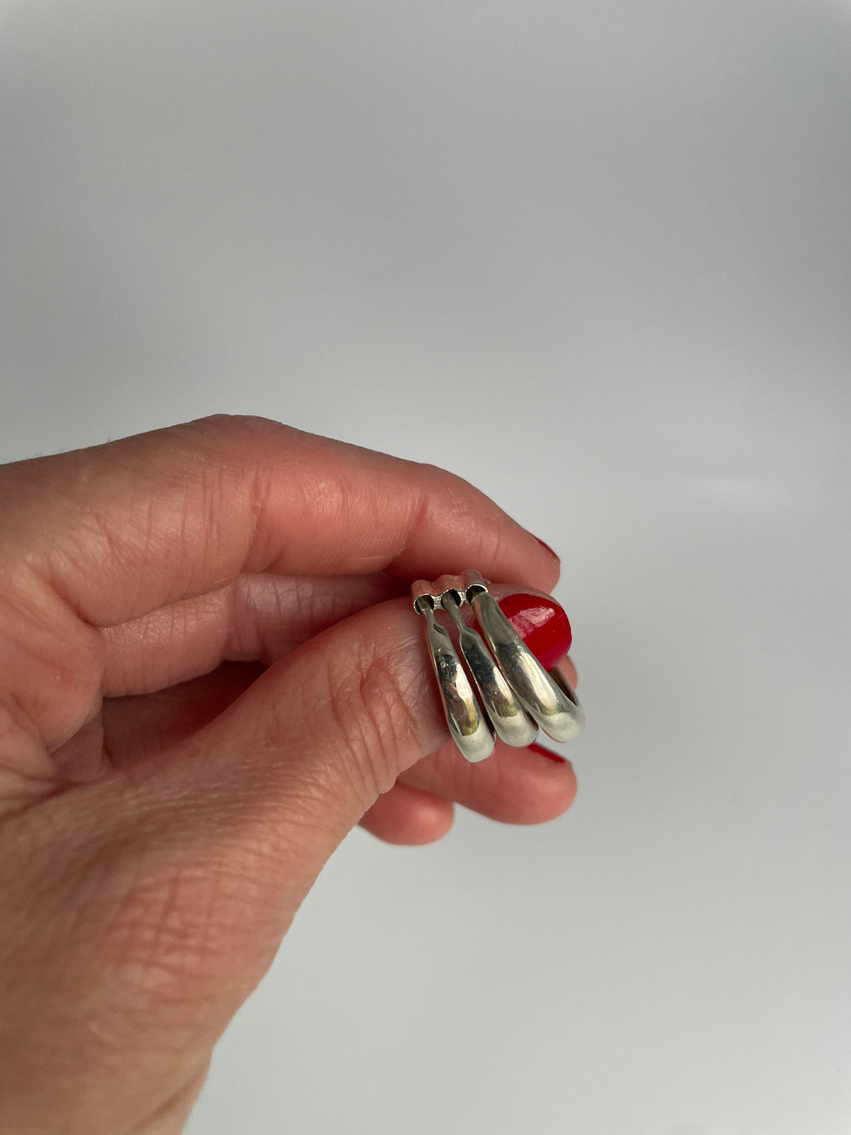 Triple domed silver ring held upright showing the three bands