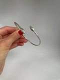 Vintage silver open cuff bracelet with ribbed cocoa pod ends, held in hand