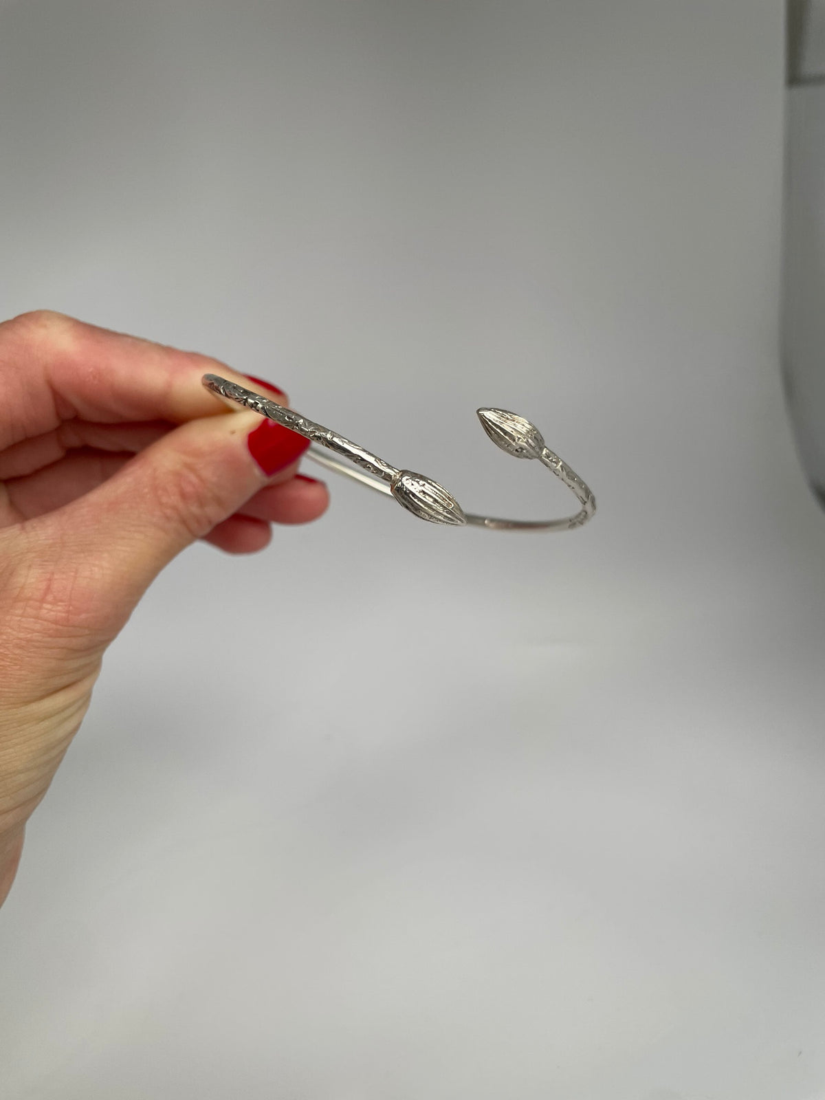 Side view of the slim silver cocoa pod cuff showing the open ends