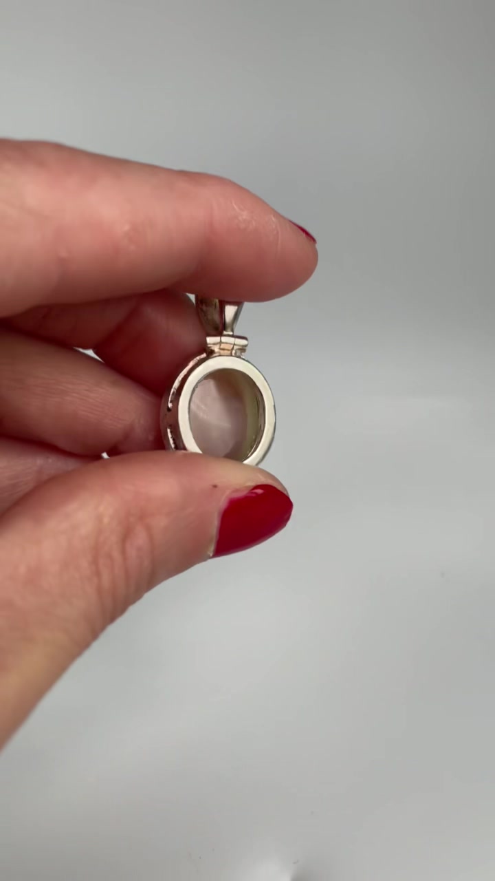 Back view of the silver cat's eye pendant showing the setting and bail join