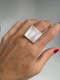 Pink mother of pearl square ring showing its rippled iridescent sheen