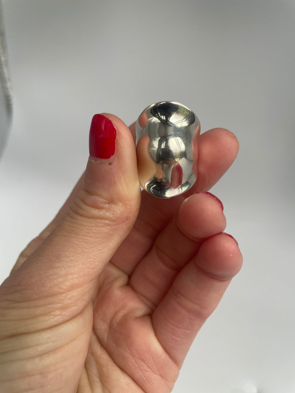 Vintage silver dome ring held up to catch the light