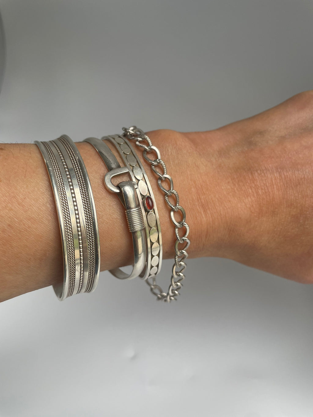 Alternating twist link bracelet on the wrist in a silver stack