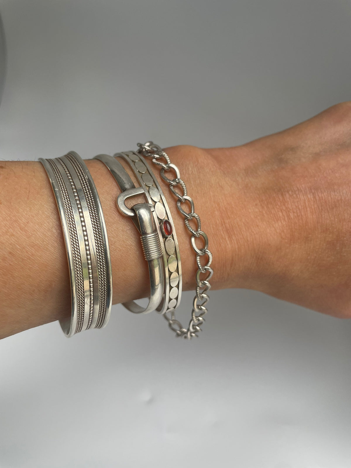 Alternating twist link bracelet on the wrist in a silver stack