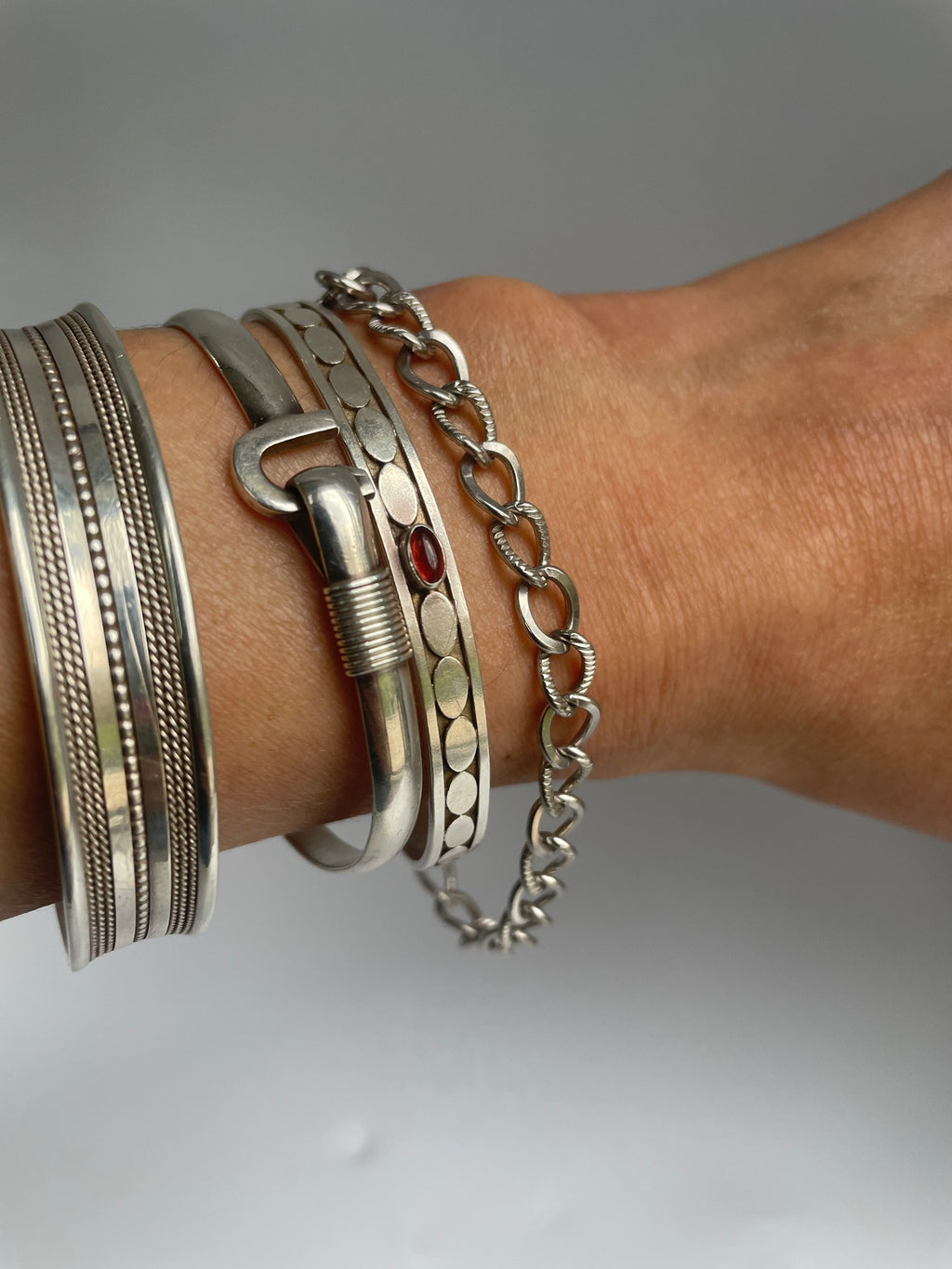 Close view of the polished and rope textured chain bracelet worn with cuffs